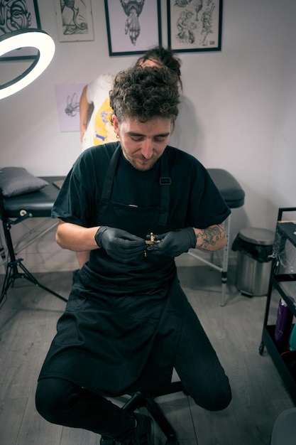 Un tatuador trabaja en un estudio de tatuaje moderno preparando el equipo