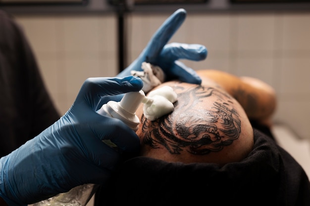 Foto tatuador de vista lateral con guantes