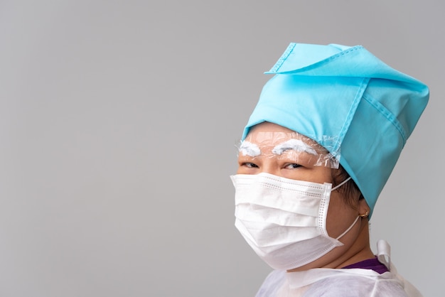 Foto tatuaje de cejas de una mujer asiática por un médico especialista en una clínica de tatuajes de cejas o una clínica de bordado de cejas para uso de tatuajes o correcciones política de prevención de covid-19 proteger mediante el uso de máscara y protector facial