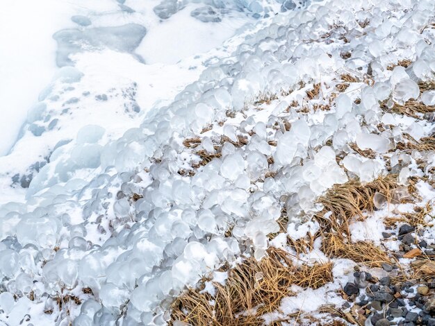 Tau über Gras wird in der Wintersaison Islands zu kristallklarem Eis und Schnee für den Hintergrund