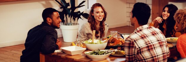 Tausendjährige erwachsene Freunde, die gemeinsam zu Hause Thanksgiving feiern