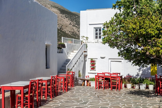 Foto taverna cafetería asientos mesas patio de adoquines fondo en la isla de sifnos grecia
