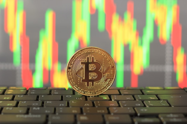 Taxa de Bitcoin no gráfico e moeda de ouro, close-up
