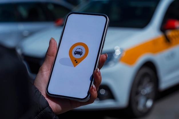 Foto táxi online em um smartphone. a garota tem o telefone nas mãos com um aplicativo móvel na tela no contexto do carro.