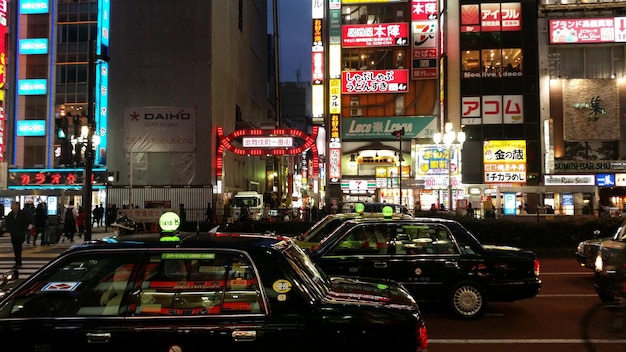Taxis en la calle contra edificios en la ciudad por la noche