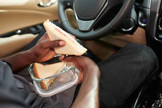 Foto taxista comiendo sándwich casero