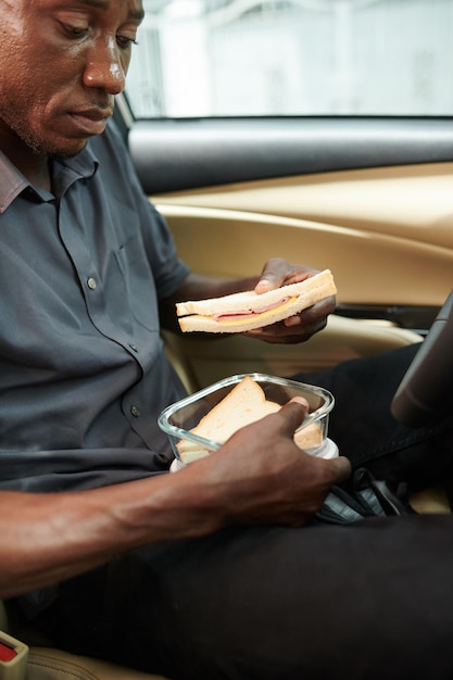 Taxista comiendo sándwich