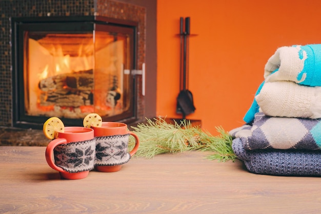 Taza con adorno de Navidad junto a la chimenea