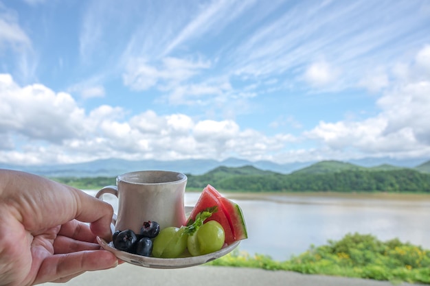 Una taza de agua y un plato de frutas.