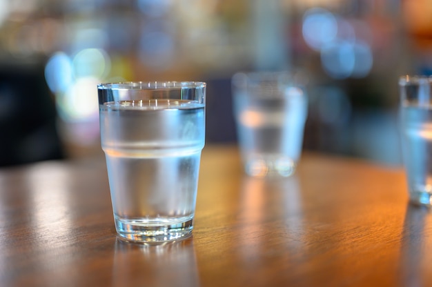 Una taza de agua en la tabla de madera lista para llevar para la bebida.