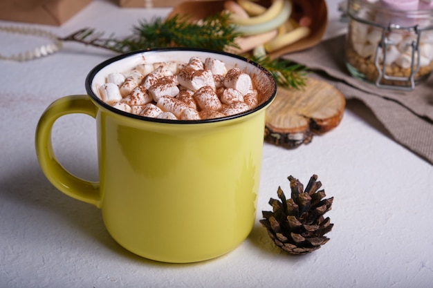 Taza amarilla con cacao decorada con malvaviscos