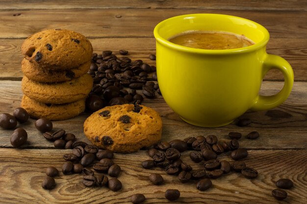 Taza amarilla de café fuerte y galletas