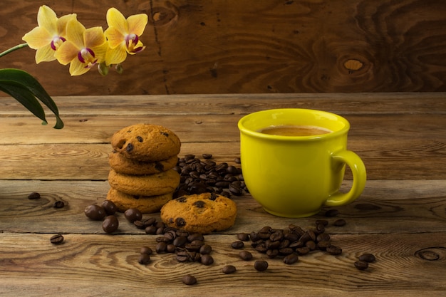 Taza amarilla de café fuerte y granos de café, espacio de copia