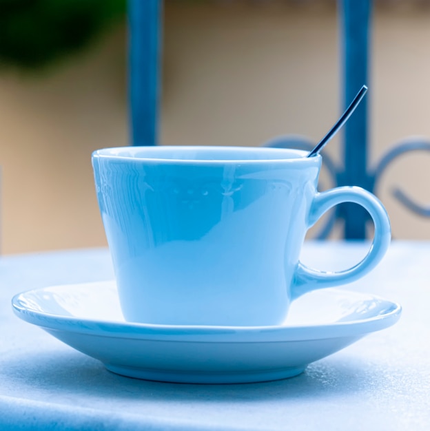 Taza azul con una cuchara sobre la mesa