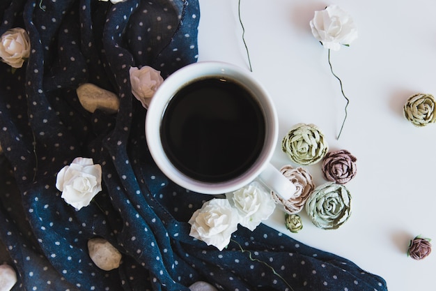 taza de bebida de café caliente con flores y tela. hogareña mañana de otoño.