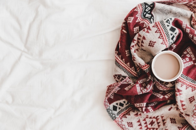 Foto taza de bebida caliente en cuadros a cuadros en sábana