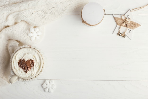 Una taza de bebida de invierno caliente con crema batida y un polvo espolvoreador