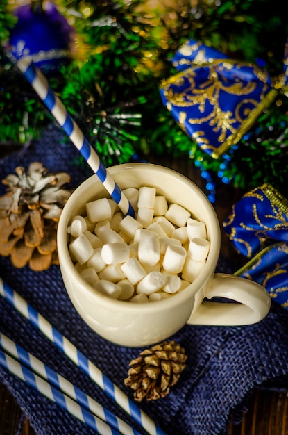 Taza de bebida con malvaviscos en decoración navideña