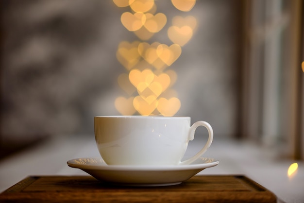 Una taza con una bebida matutina caliente y vigorizante con luces en forma de corazones