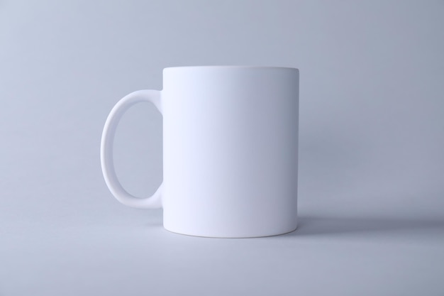 Una taza blanca en blanco sobre un fondo claro Maqueta para el diseño