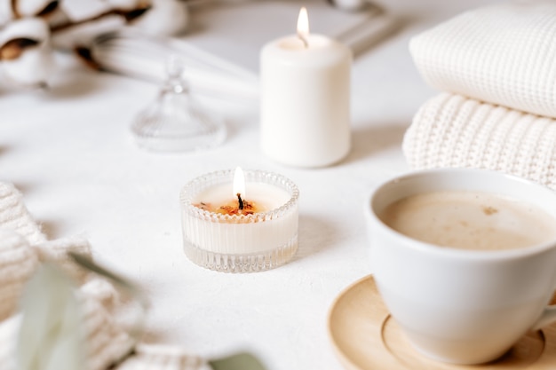 Taza blanca de café, algodón, velas.