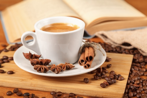 Foto taza blanca de café espresso rodeada de granos de café tostados