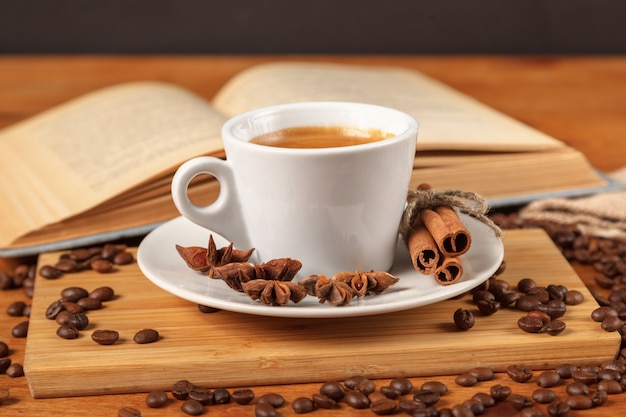 Foto taza blanca de café espresso rodeada de granos de café tostados