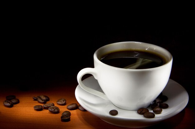 Taza blanca de café y frijoles en textura de madera