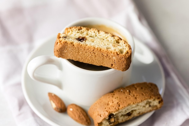 Taza blanca de café fuerte servido con galletas de almendras italianas Cantucci fondo gris arriba