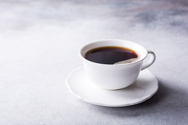 Taza blanca de café con galletas amaretti.