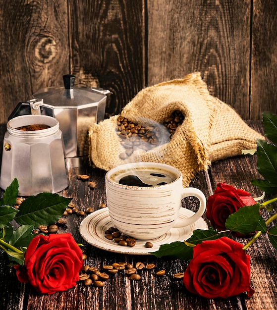 Taza blanca de café con granos de café al vapor en una bolsa cafetera géiser Día Internacional del Café