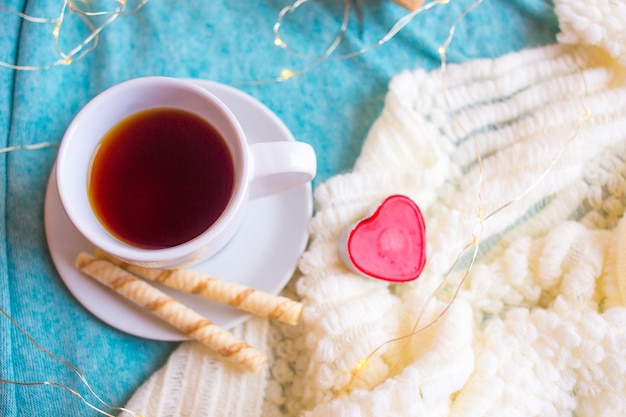 Taza blanca con café o té y un corazón rojo