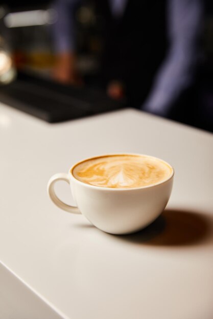 una taza blanca de capuchino caliente y sabroso