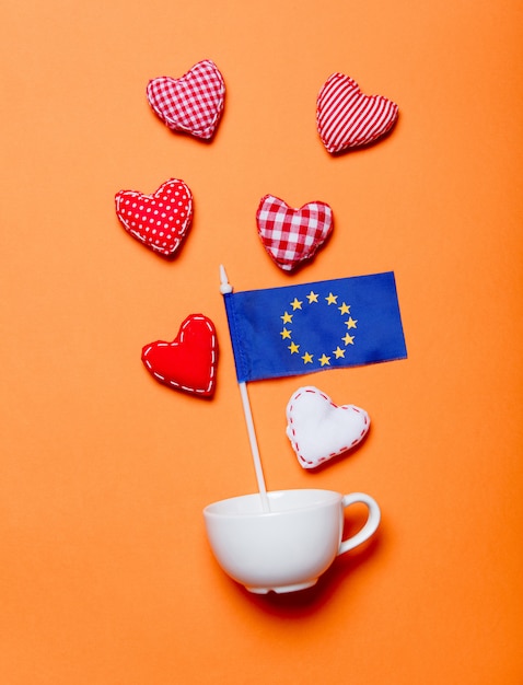 Taza blanca y formas de corazón con la bandera de la Unión de Europa.