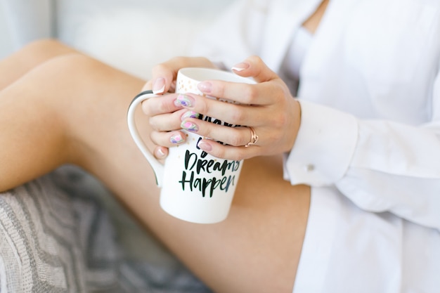 Foto taza blanca en manos de mujer