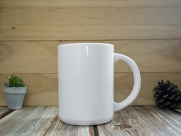 La taza blanca en la mesa de madera para maqueta o fondo