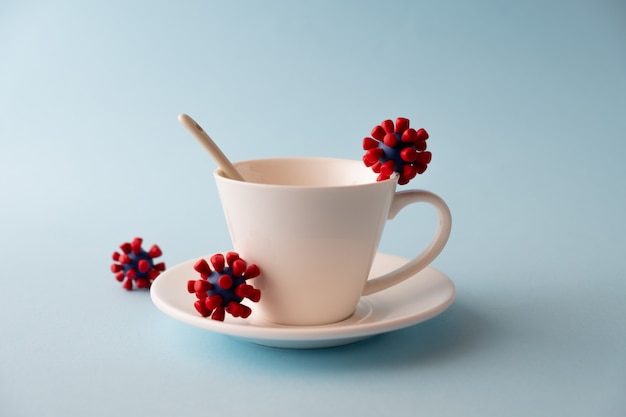 Taza blanca con modelos de virus covid-19. Coronavirus epidémico. Riesgo de infección Concepto COVID-19.