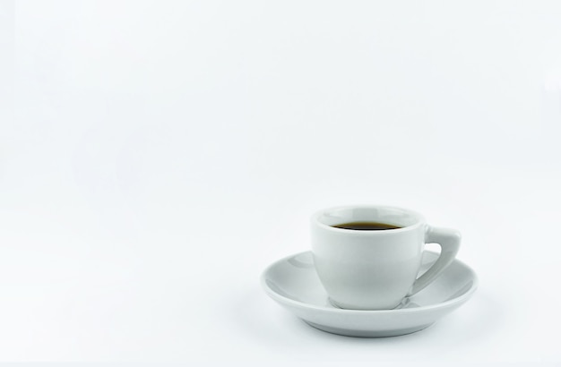 Taza blanca en un platillo con café