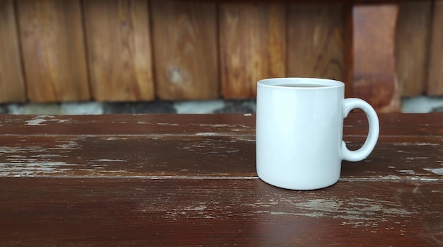 Taza blanca de primer plano de té sobre una superficie de madera. Buenos días concepto al aire libre día helado de invierno