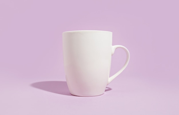 Taza blanca sobre un fondo morado sólido