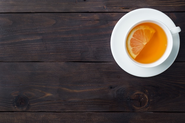 Taza blanca con té de hierbas natural con limón.