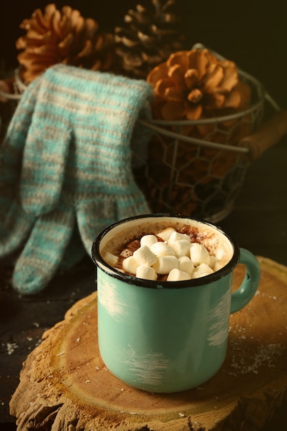 Taza de cacao caliente con malvavisco y guantes de mesa negra