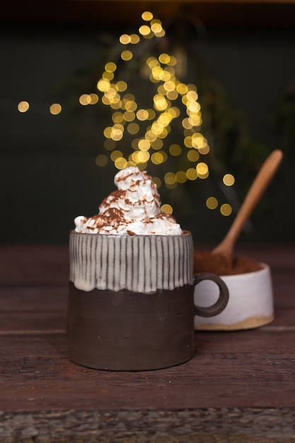 Una taza de cacao y crema con bokeh de fondo