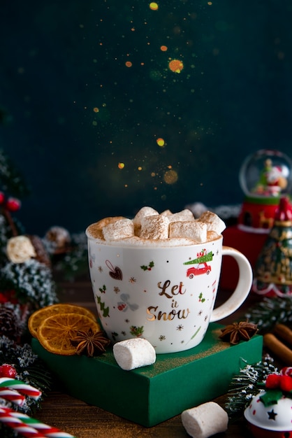 Taza de cacao con malvaviscos en la decoración navideña