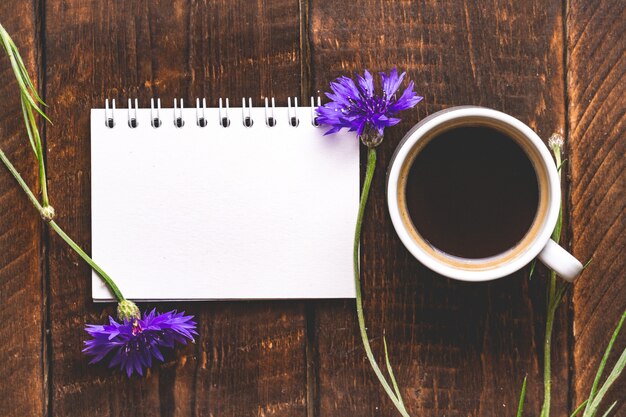 Foto taza de café con acianos. vista superior. café y flores. copia espacio