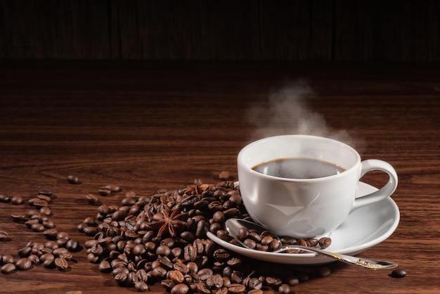 Taza de café ahumado con cuchara en granos de café