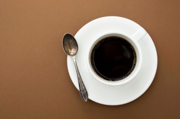 Taza de café aislada en la mesa marrón. Bebida de café con espacio de copia.