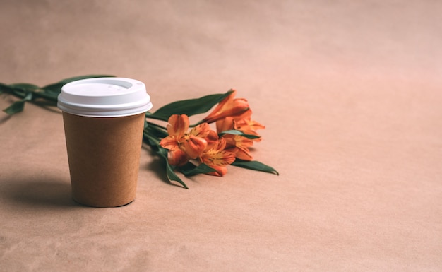 Taza de café y alstromeria sobre un fondo artesanal