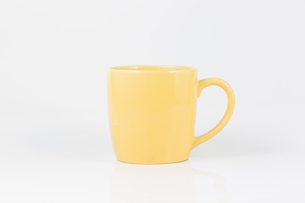 Taza de café amarilla sobre un fondo blanco