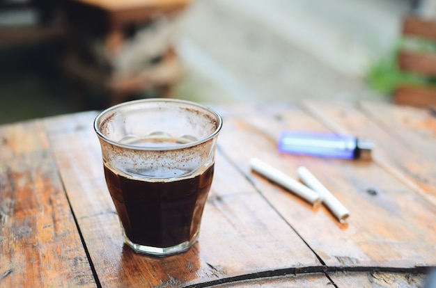 Taza de café americano negro caliente en la mesa de madera
